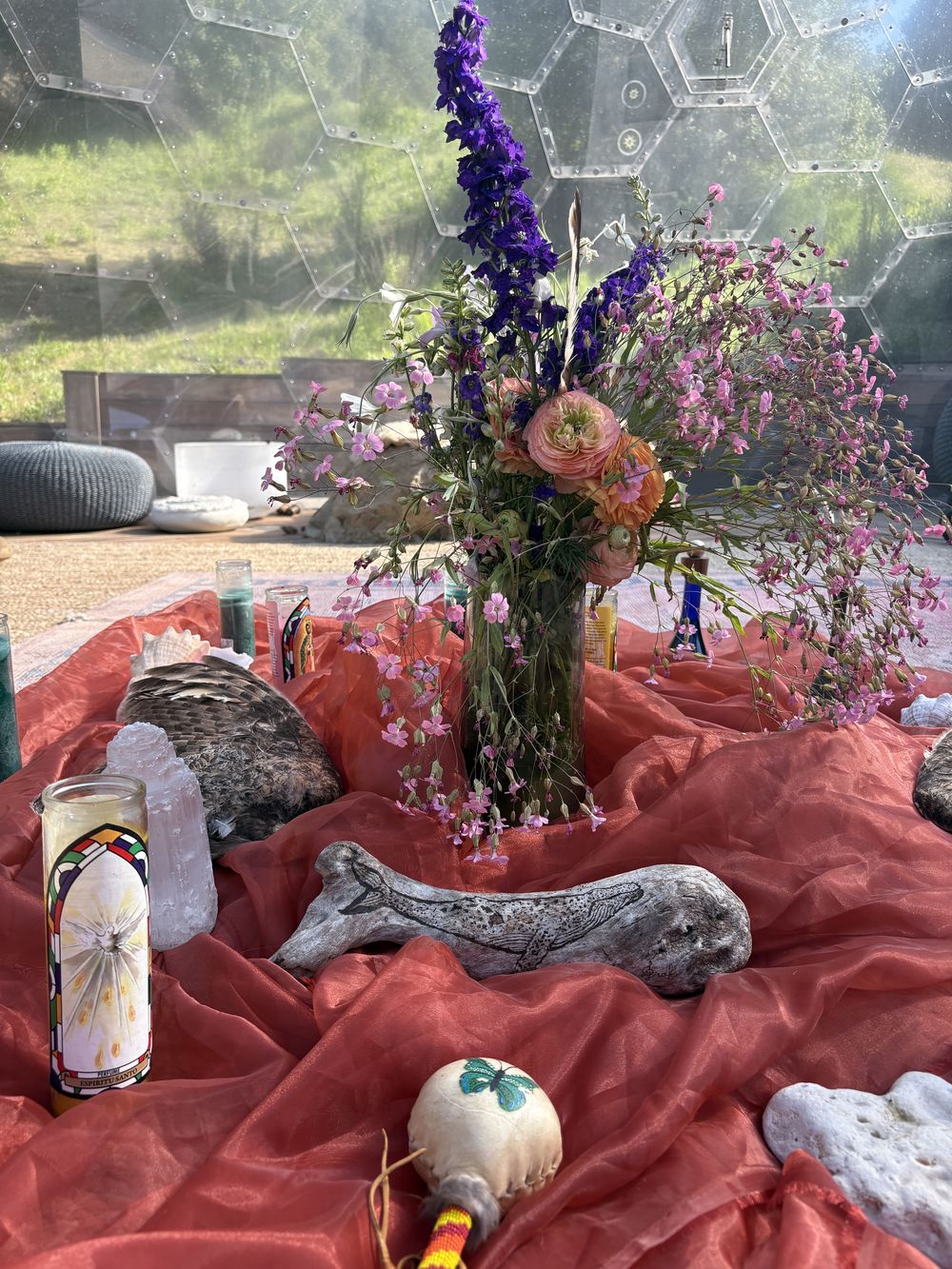 Her altar — wildflowers, a carved whale, feather and candlelight